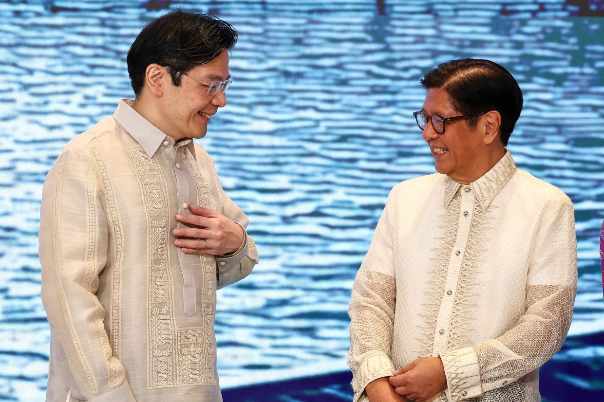 Singapore's Prime Minister Lawrence Wong reacts next to Philippine President Ferdinand Marcos Jr. ahead of the gala dinner at the 48th ASEAN summit, in Cebu, Philippines, on Friday, May 8, 2026. -- Photo: REUTERS/Eloisa Lopez