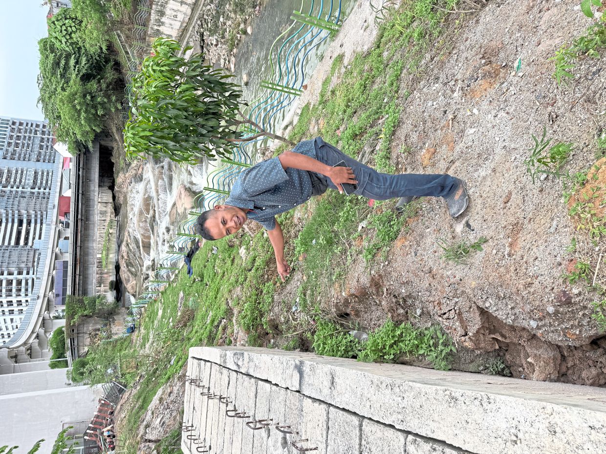 A resident whose house is located beside Lorong 7a of Taman Kayu Ara Indah showing the degree of erosion at the banks of Sungai Kayu Ara.