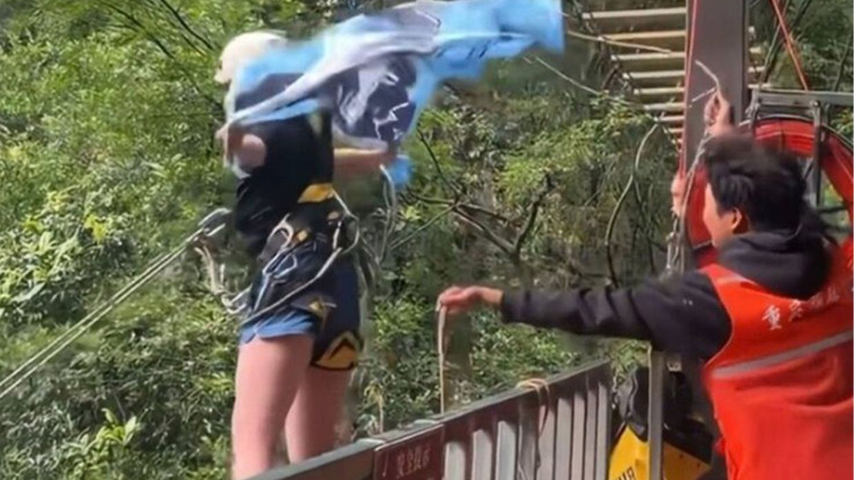 As Liu was perched on the edge of the platform, she was heard yelling “not tied tightly” multiple times. However, a worker still pushed her out.