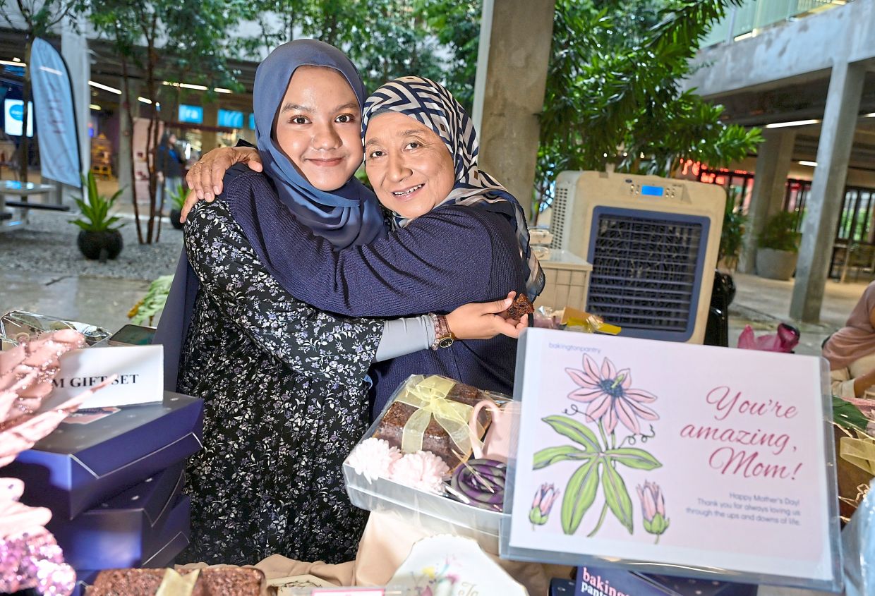 It’s a family thing: Zaiton (right) and her granddaughter Alysha at their Mothers Day Market stall where they sell the results of Zaiton’s passion, baking.