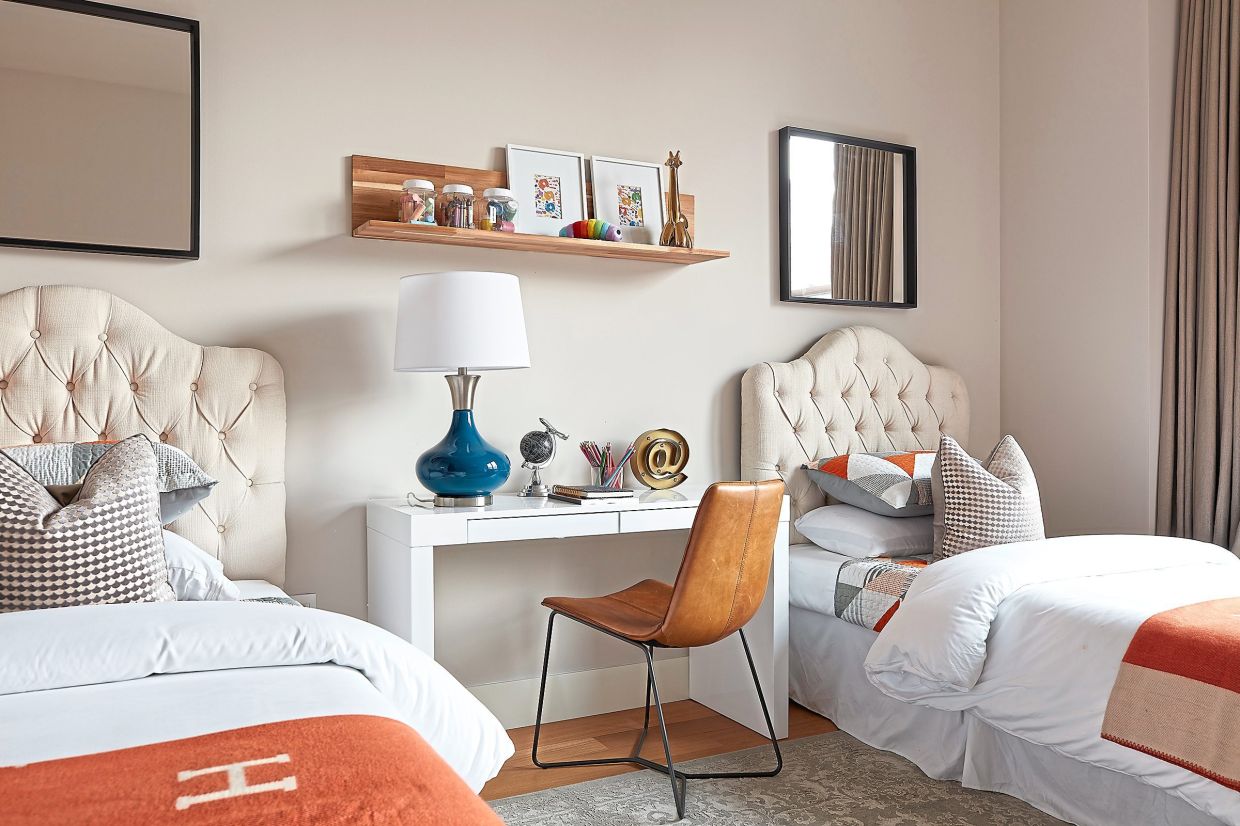 A desk with shelf is used as a room divider and shared space in this children's bedroom.