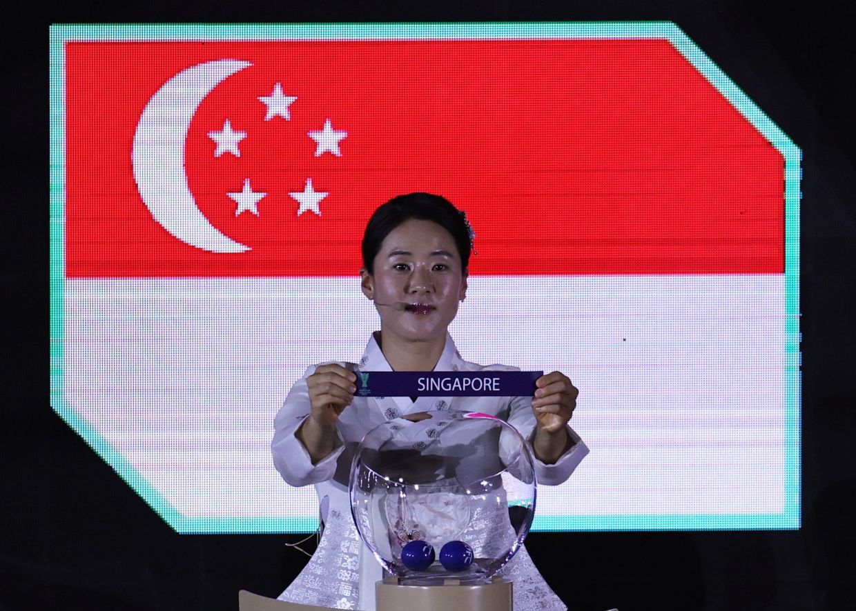 Referee Kim Yujeong draws Singapore during the group stage draw for the AFC Asian Cup, which was held in Riyadh, Saudi Arabia. -- Photo: REUTERS/Hamad I Mohammed