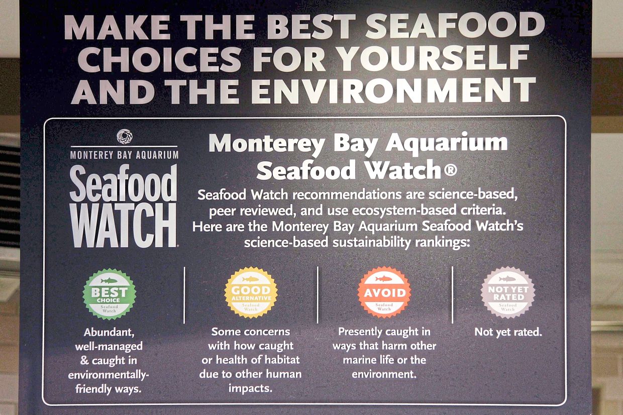 A Seafood Watch sign with a colour-coded rating programme hangs over the seafood counter in Whole Foods in Hillsboro, Oregon. 