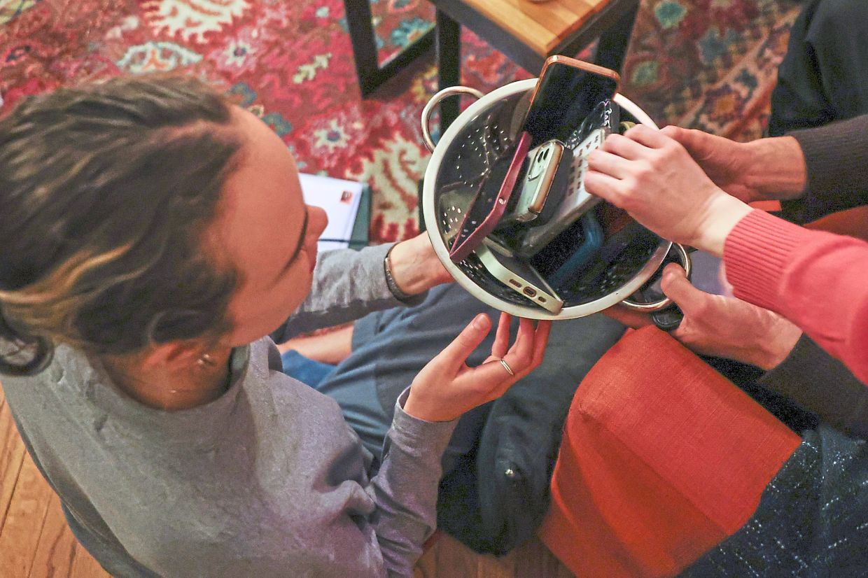 Guests collect their smartphones at the end of a phone-free gathering.