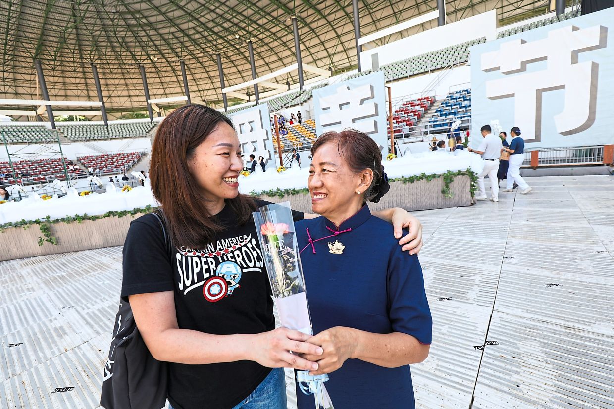 Winnie Heng Ing Ing giving her mother Low Jou Hong a flower during the Mothers Day, Wesak Day and Buddhist Tzu-Chi Foundation event.