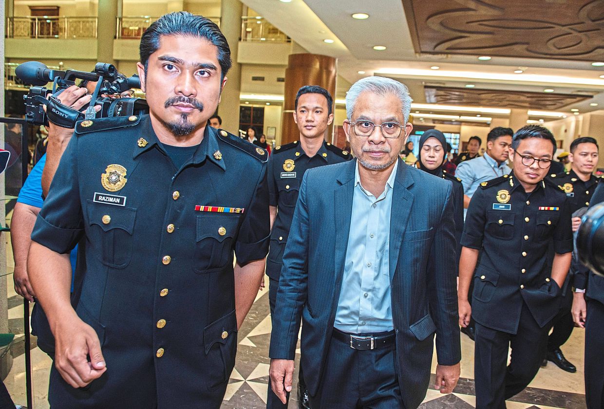 Day in court: Mohd Daud (centre) making his way to the Sessions Court in Kuala Lumpur. — Bernama