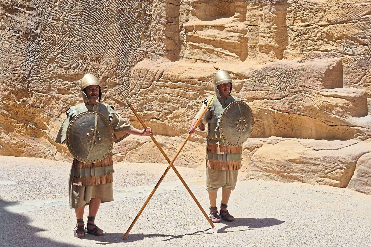 Nabatean Guards in their traditional uniform holding spears at the Siq of Petra, waiting for tourists.