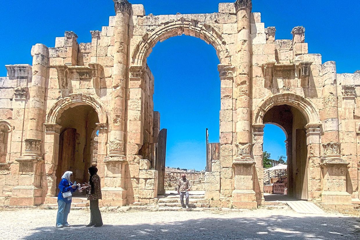 Visitors at the Roman-era South Gate of Jerash, built in honour of the Roman Emperor Hadrian. 