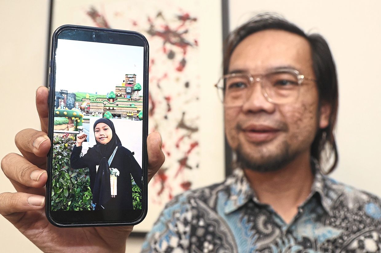 Meor Azimudin showing a photo of his daughter, Nur Safiyya Hanania. Photo: The Star/Azman Ghani