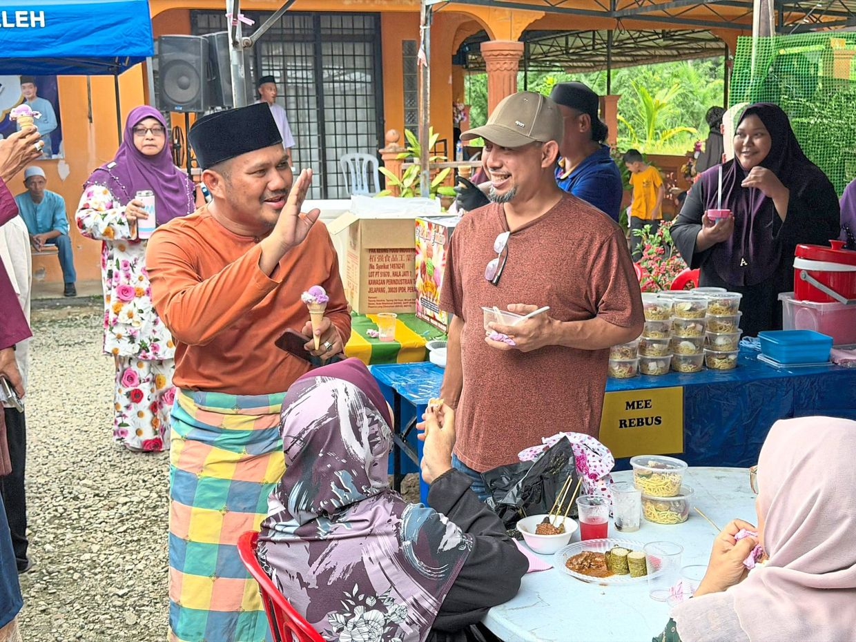 Mohamad Fazli (left) mingling with attendees at the Raya Sekampung Bangsa Johor event at Kampung Semeriut, Muar.