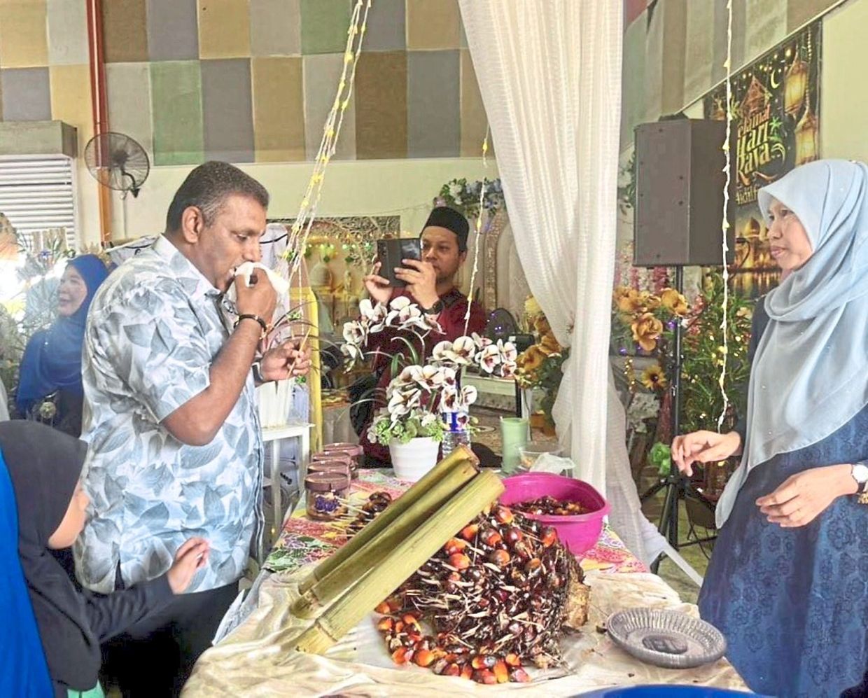 Raven Kumar sampling some of the food at Raya Sekampung in Felda Tenggaroh 5, Mersing.