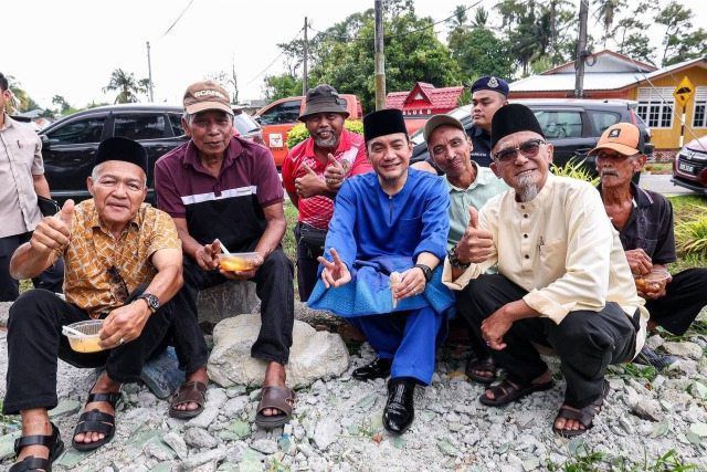 Onn Hafiz (in blue) taking a group shot with attendees at one of the Raya Sekampung Bangsa Johor events in his Machap constituency.