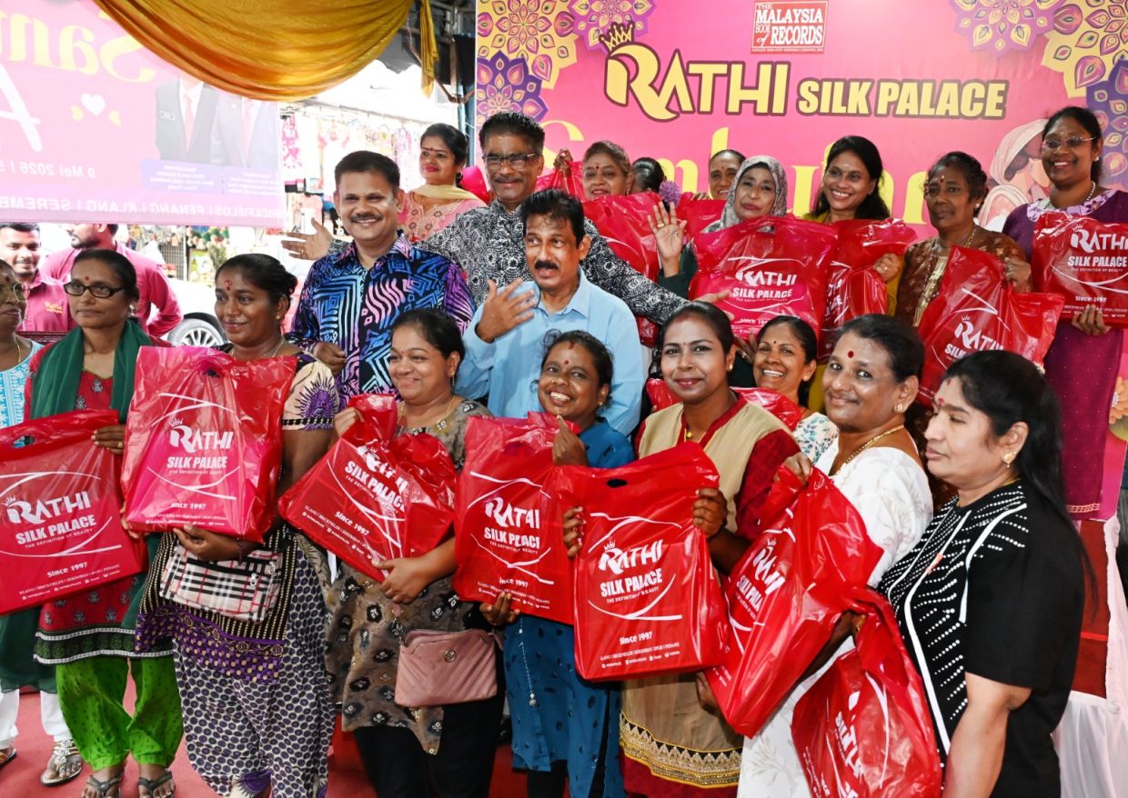 State Housing and Environment committee chairman Datuk Seri S. Sundarajoo (in black and white batik), Rathi Silk Palace directors Datuk L. Gandesan (in light blue shirt) and Datuk Jinnah (colourful batik) posing with the saree recipients on May 9. ( May 9, 2026 ) — K.T.GOH/The Star