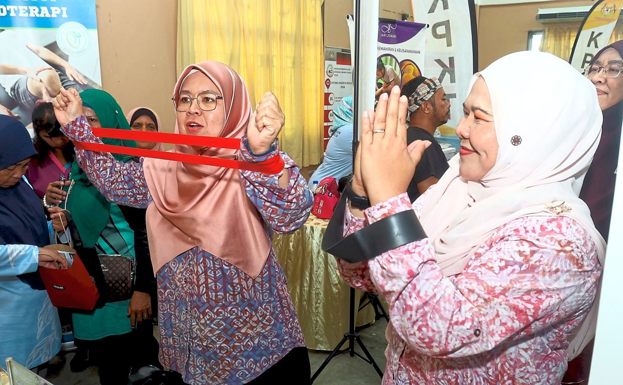 Salbiah (right) trying out an exercise band during WE Fit 2026.