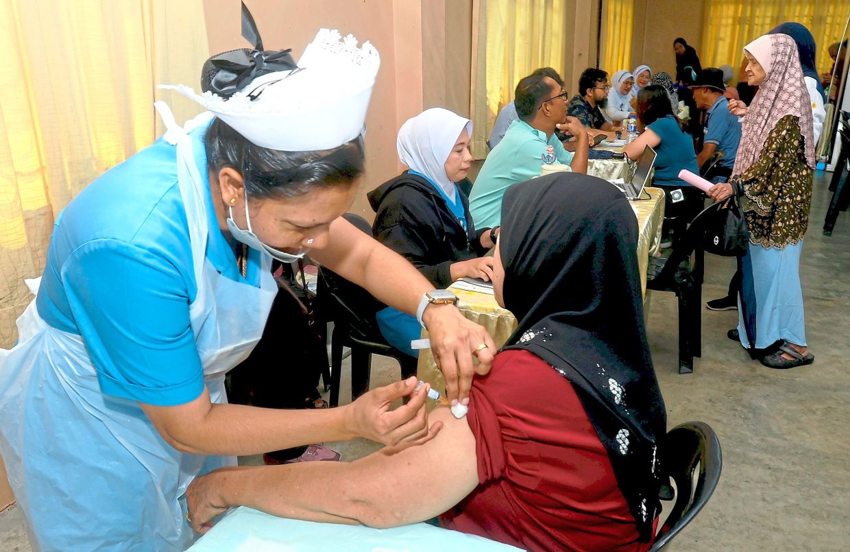 A nurse giving a free flu jab to a participant.