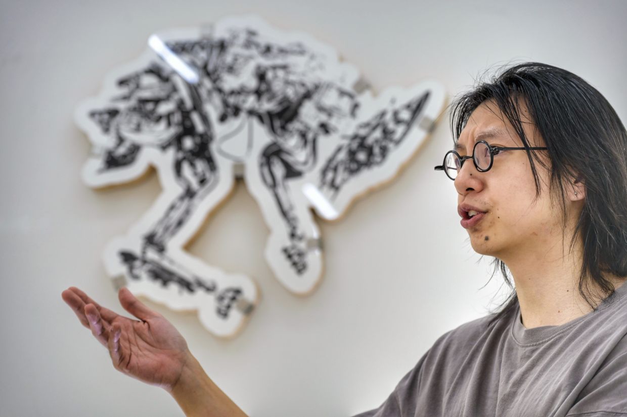 Artist Silas Oo in conversation at his debut gallery solo 'Roadkill' at The Back Room in Kuala Lumpur. Photo: The Star/Raja Faisal Hishan