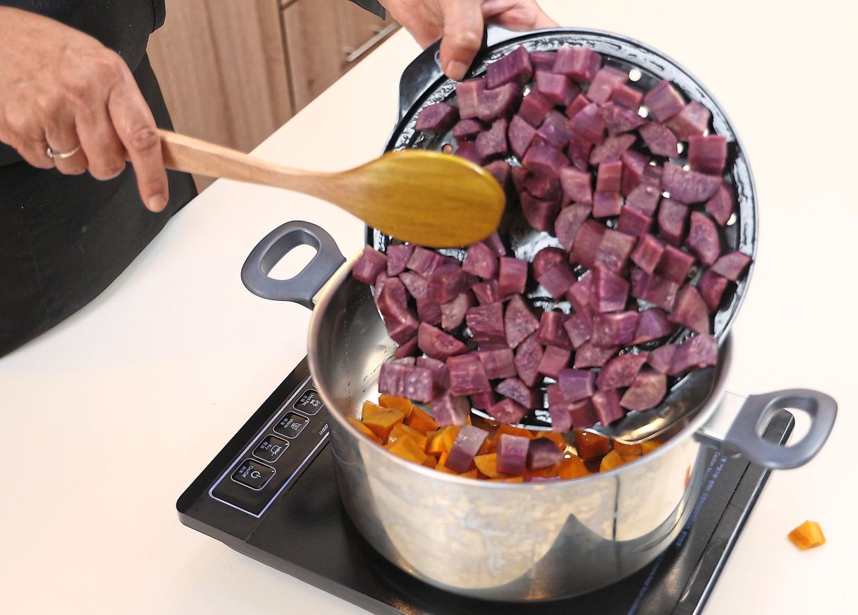 Add the steamed sweet potatoes into a large and deep pot.