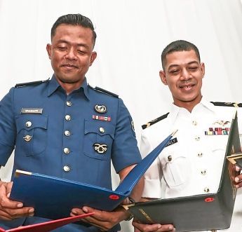 Mohd Ghadaffi and Mohd Suhaily Azlan (in white uniform) proudly showing off their certificates of completion.