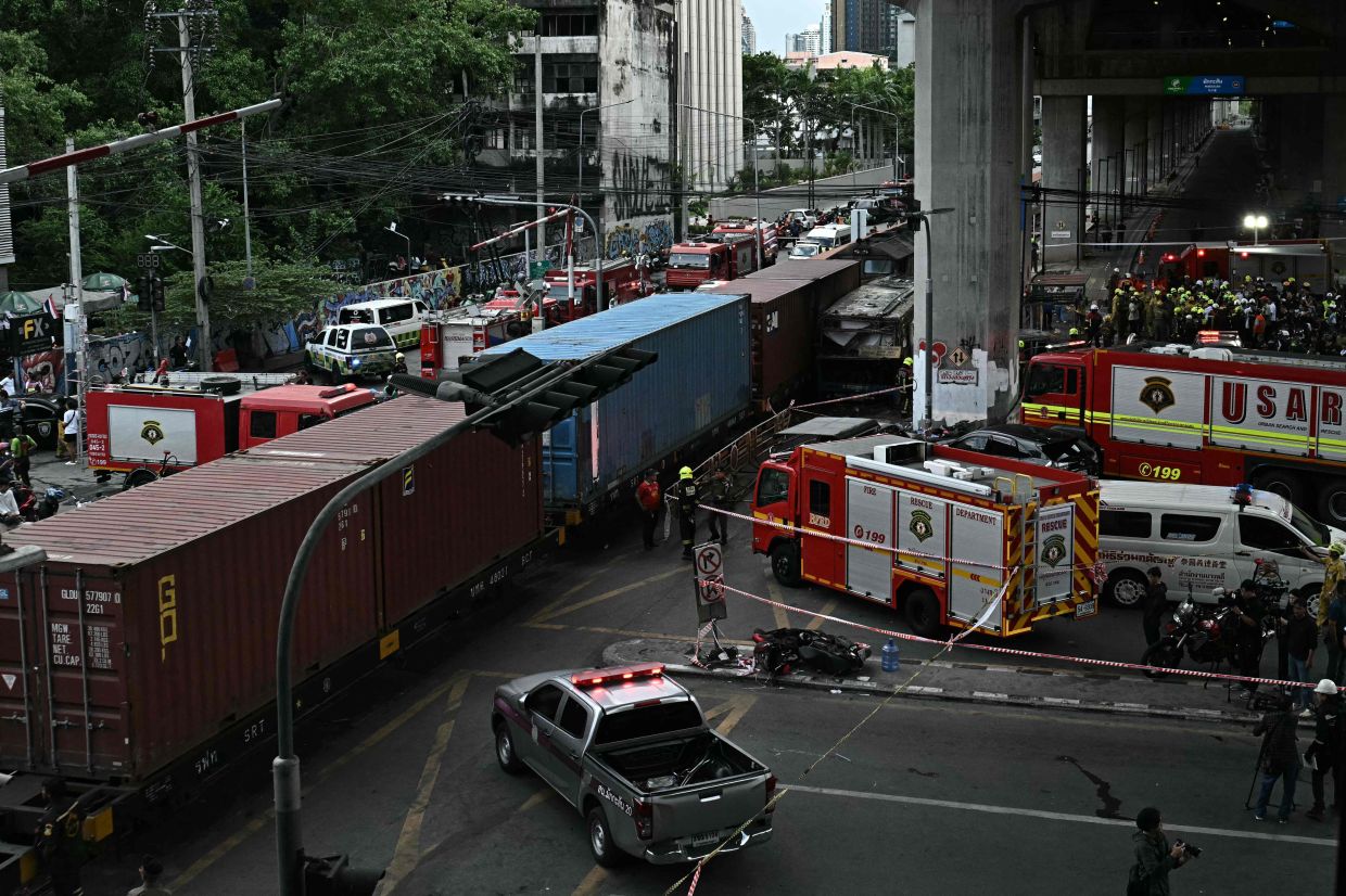 Police officers, rescue workers, and firefighters stand at the site of a train collision with a bus underneath Makkasan Airport Rail Station in Bangkok on Saturday, May 16, 2026. A collision between a freight train and a bus killed at least eight people and injured more than 30 in the Thai capital, Bangkok, emergency services said. -- Photo by Lillian SUWANRUMPHA / AFP