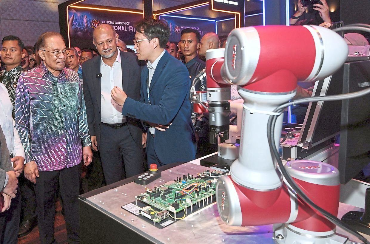 Gobind with Prime Minister Datuk Seri Anwar Ibrahim at an exhibition held during the launch of the National AI office at MITEC in Kuala Lumpur. — AZHAR MAHFOF/The Star