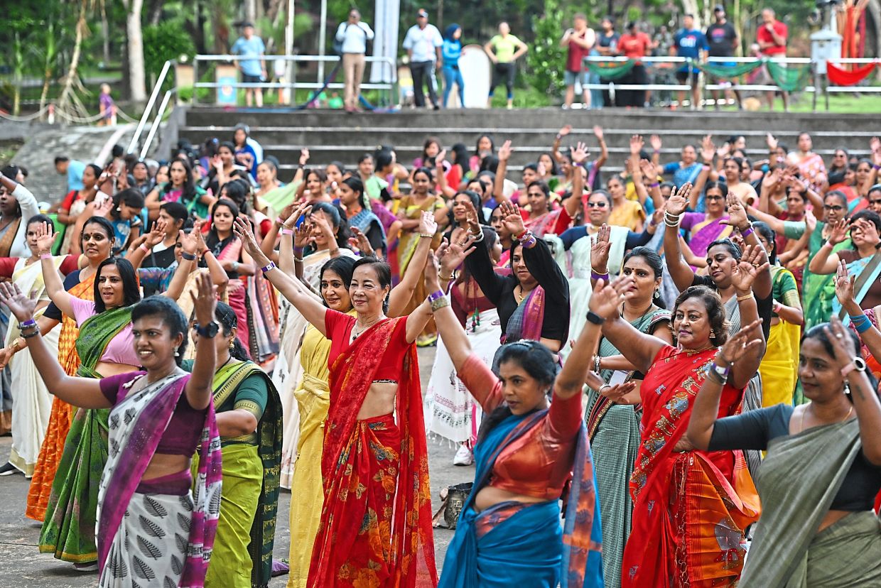 Lim (second row, centre, in red saree) says she was surprised by how comfortable the outfit is and plans to buy her own.