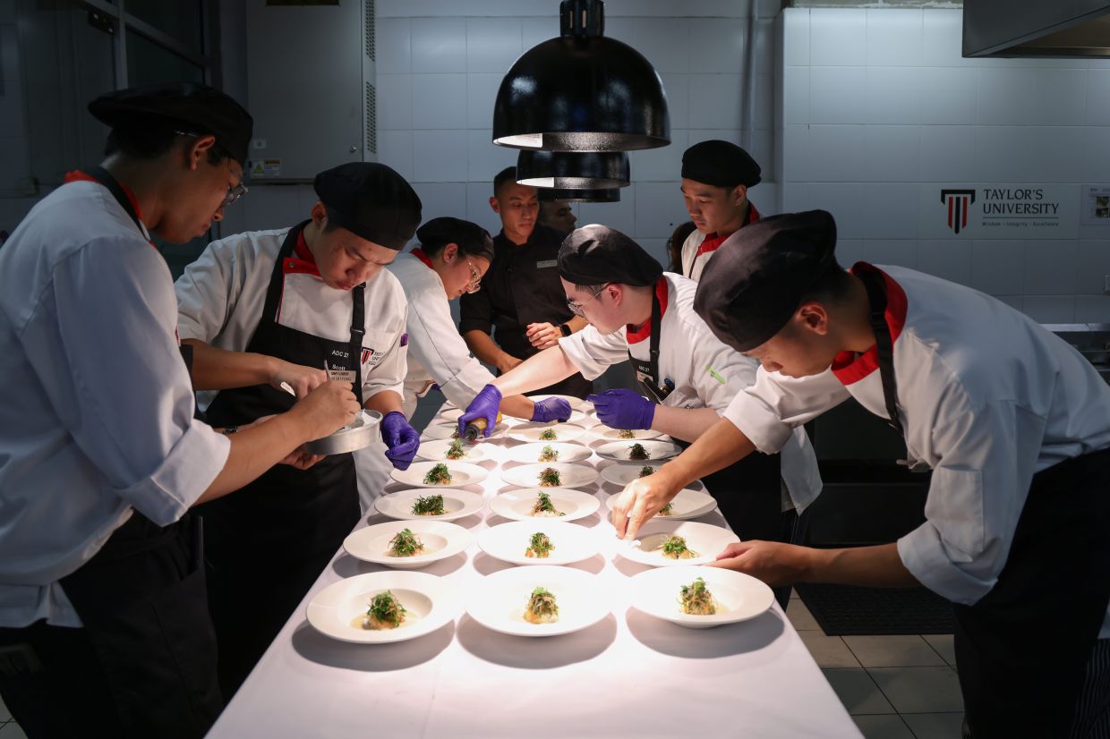 COL students meticulously plating the starter under the watchful eye of chef Bustara (centre, in black). — GLENN GUAN/The Star