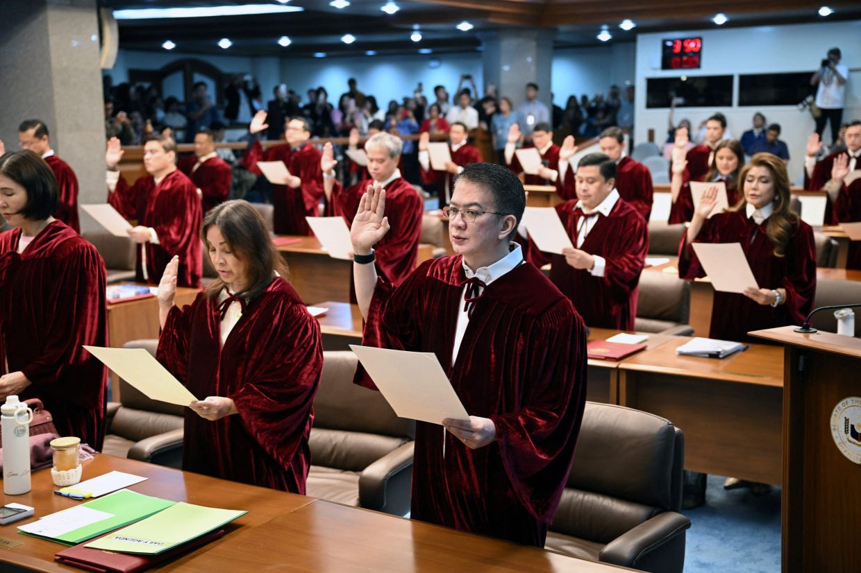 Philippine senators take their oath as jurors in the impeachment trial of Vice President Sara Duterte at the plenary hall of the Senate in Manila. Philippine lawmakers were sworn in on May 18 to serve as judges in the trial of impeached Vice President Sara Duterte, the second attempt since last year to force her from office. -- Photo by Ted ALJIBE / AFP