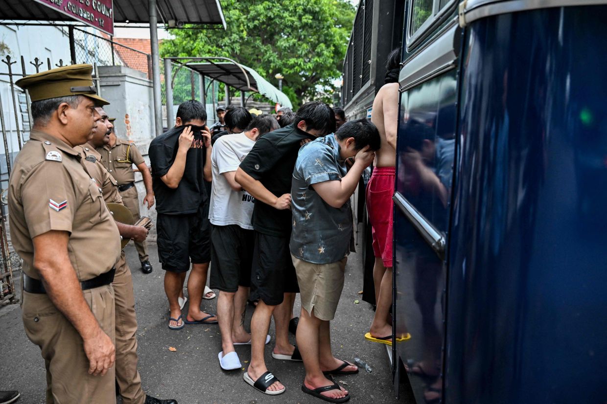 Prison guards escort detained Chinese nationals suspected of running cyber scam centres to a prison after their arrest in Colombo. A surge in arrests of suspected foreign scammers in Sri Lanka has authorities concerned that the island is fast becoming a hub for online crime, following sweeping crackdowns in hotspots Cambodia and Myanmar. -- Photo by Ishara S. KODIKARA / AFP