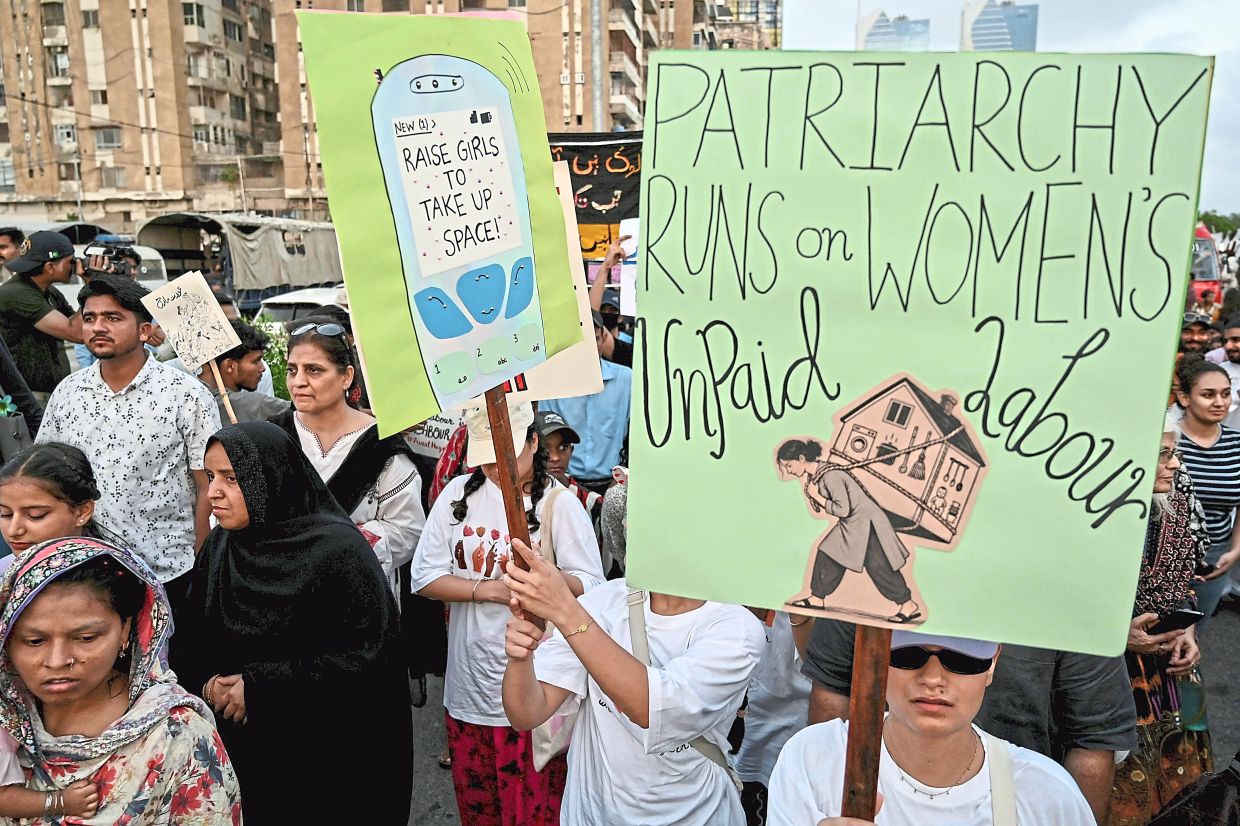 Demonstrators carrying placards during a Mothers Day rally organised by women’s rights group Aurat March in Karachi, Pakistan. — AFP