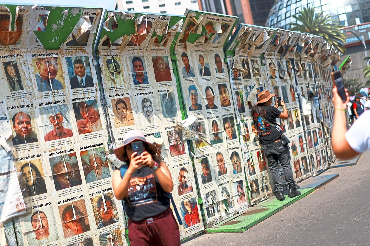 Families of the disappeared standing beside posters of missing loved ones during a Mothers Day march calling for justice and an end to impunity at the Roundabout of the Disappeared in Mexico City, Mexico. — Reuters
