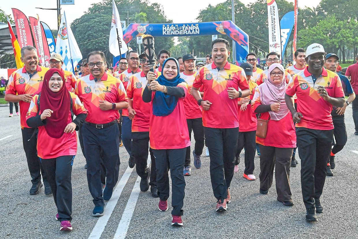 The torch, pictured here carried by shah alam mayor datuk Zabidahsafar with Mohd Najwan to her left, will tour selangor in the run-up to sukmaand Para sukma 2026.