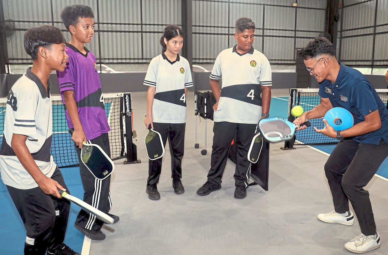 A trainer (right) sharing tips on paddle technique for a more masterful pickleball game. 