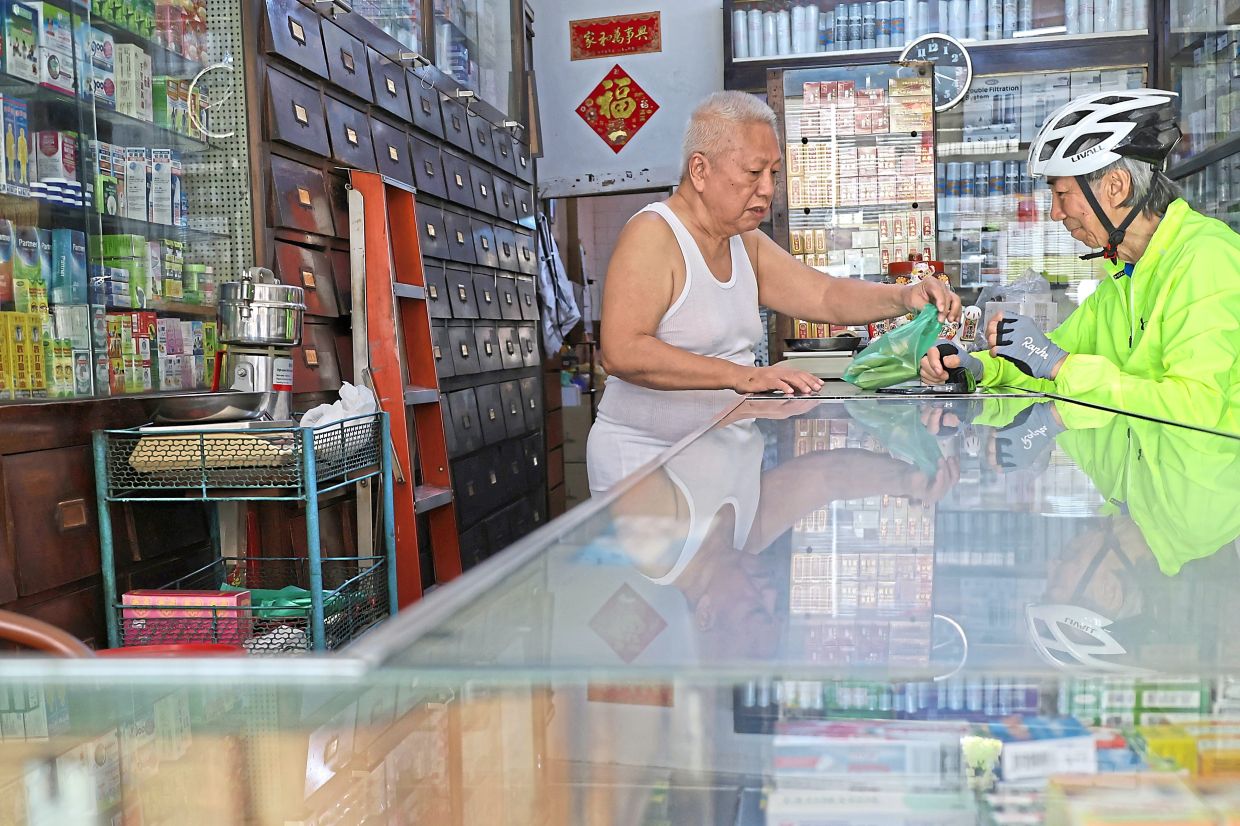 Medicine shop owner Chew says his business on Jalan Burma has dropped by 40% after the railings were installed. 