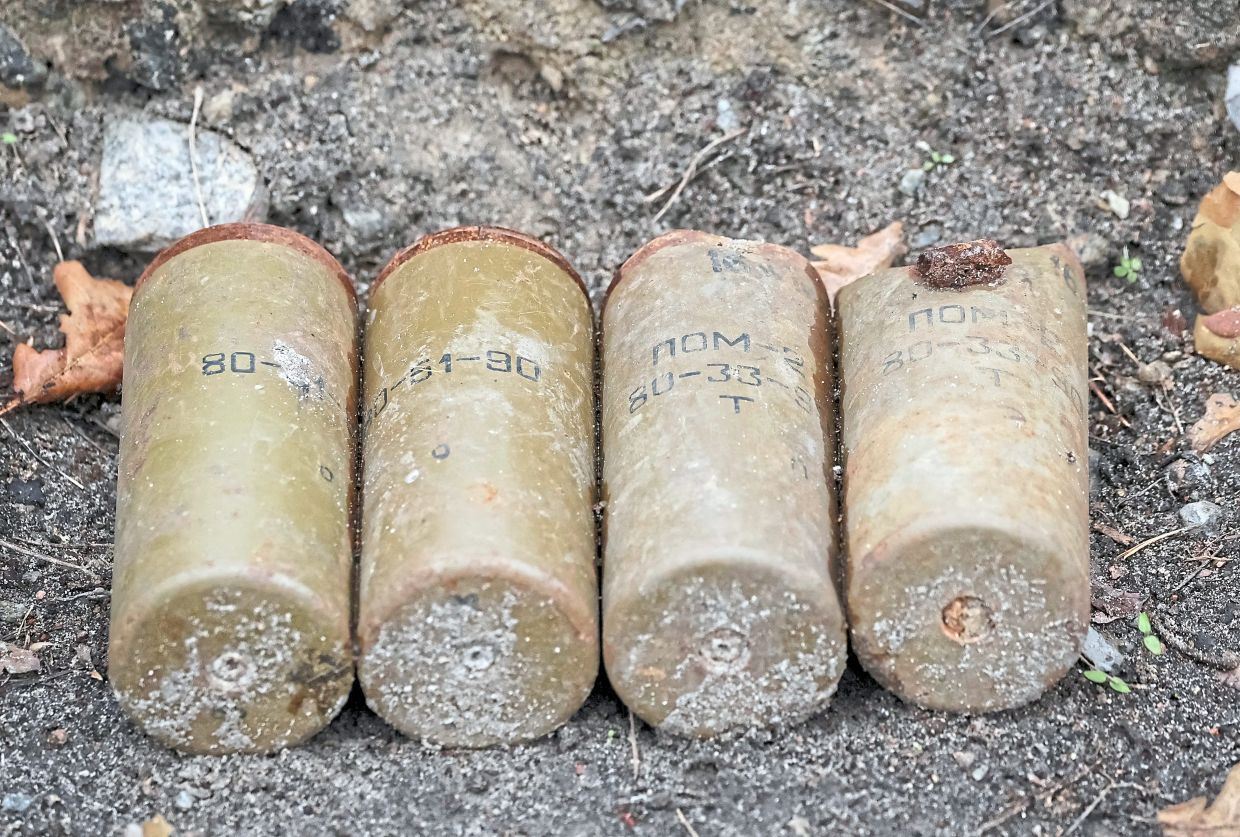 Parts of Russian landmines and unexploded ordnance (below) found in a forest in the Kyiv region. — Reuters