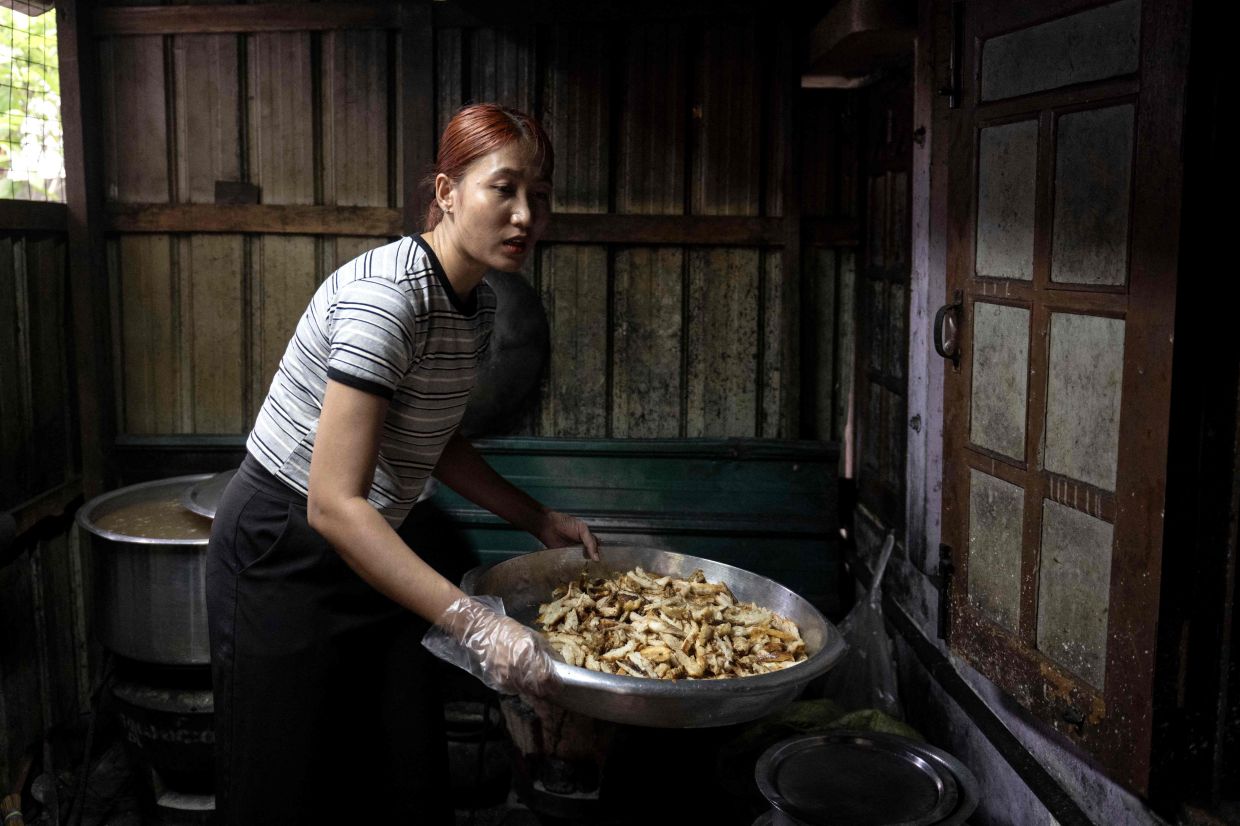 A woman cooks at a Rakhine traditional food restaurant in Yangon in Yangon.