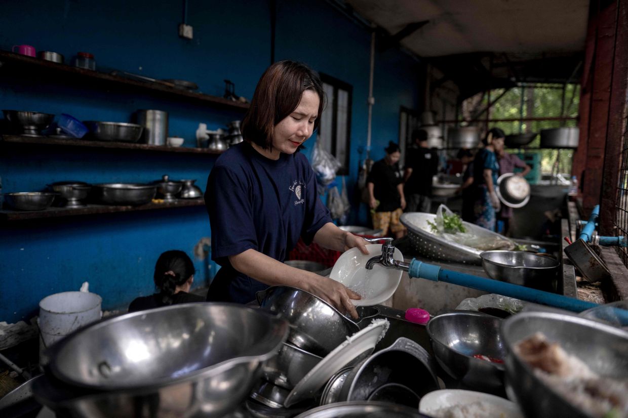 A worker cleans dishes at a Rakhine traditional food restaurant in Yangon.