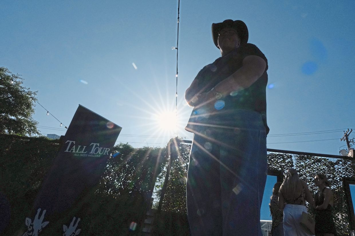 Sam Koban, who is seven feet three inches (2.2m) tall stands outside the event.