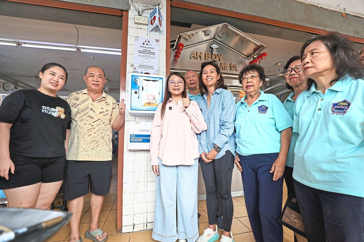 Jamaliah launching the AED at Restoran Golden Kim Wah Lee in Petaling Jaya with Yip (second from left) and residents.