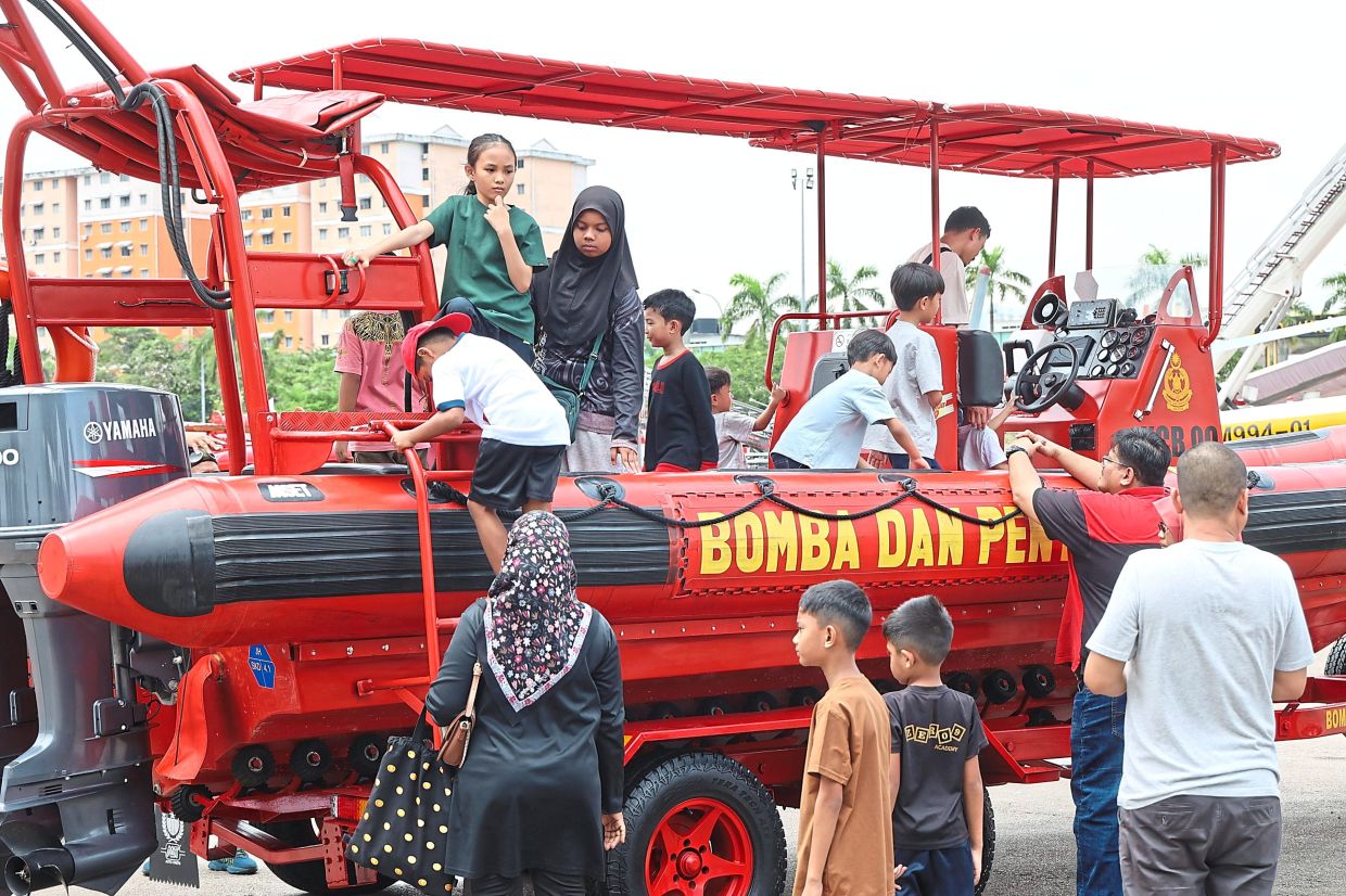Visitors exploring a fire and rescue boat.