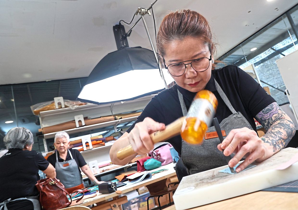 Hue hammering away her stress while leather crafting.