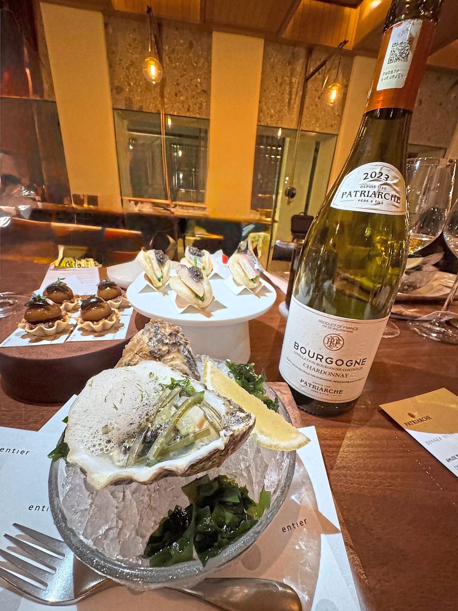 The Bourgogne Chardonnay 2023 paired with (clockwise) a fresh oyster and seaweed, ‘pissaladiere’ and smoked mackerel bun with caviar.