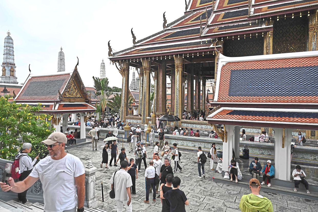 New limits: Visitors walking around the Grand Palace in Bangkok. Thailand is drastically cutting the length of visa-free stays for tourists from more than 90 countries in an effort to curb crime involving foreign nationals. — AFP