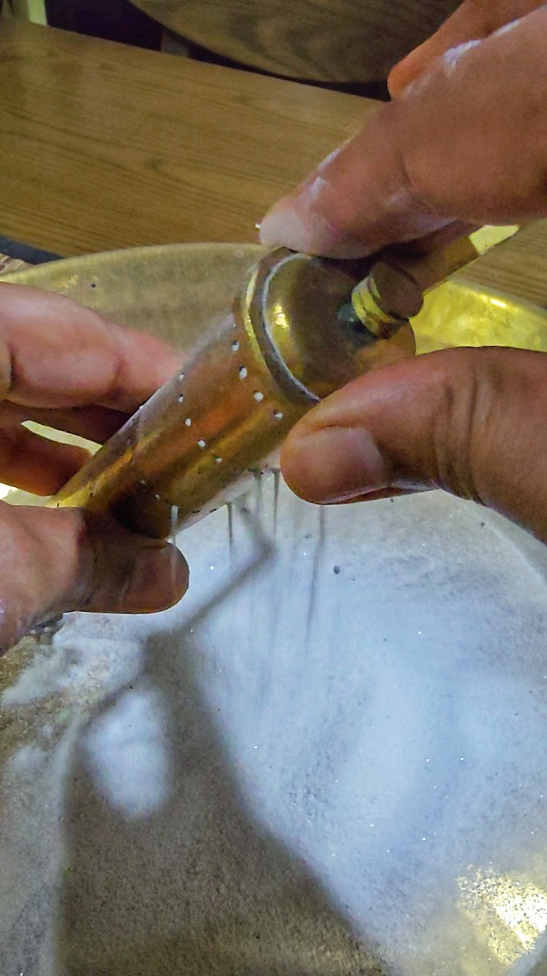 A kola kuzhal is a traditional pipe-shaped instrument used for drawing parallel-line borders in kolams.