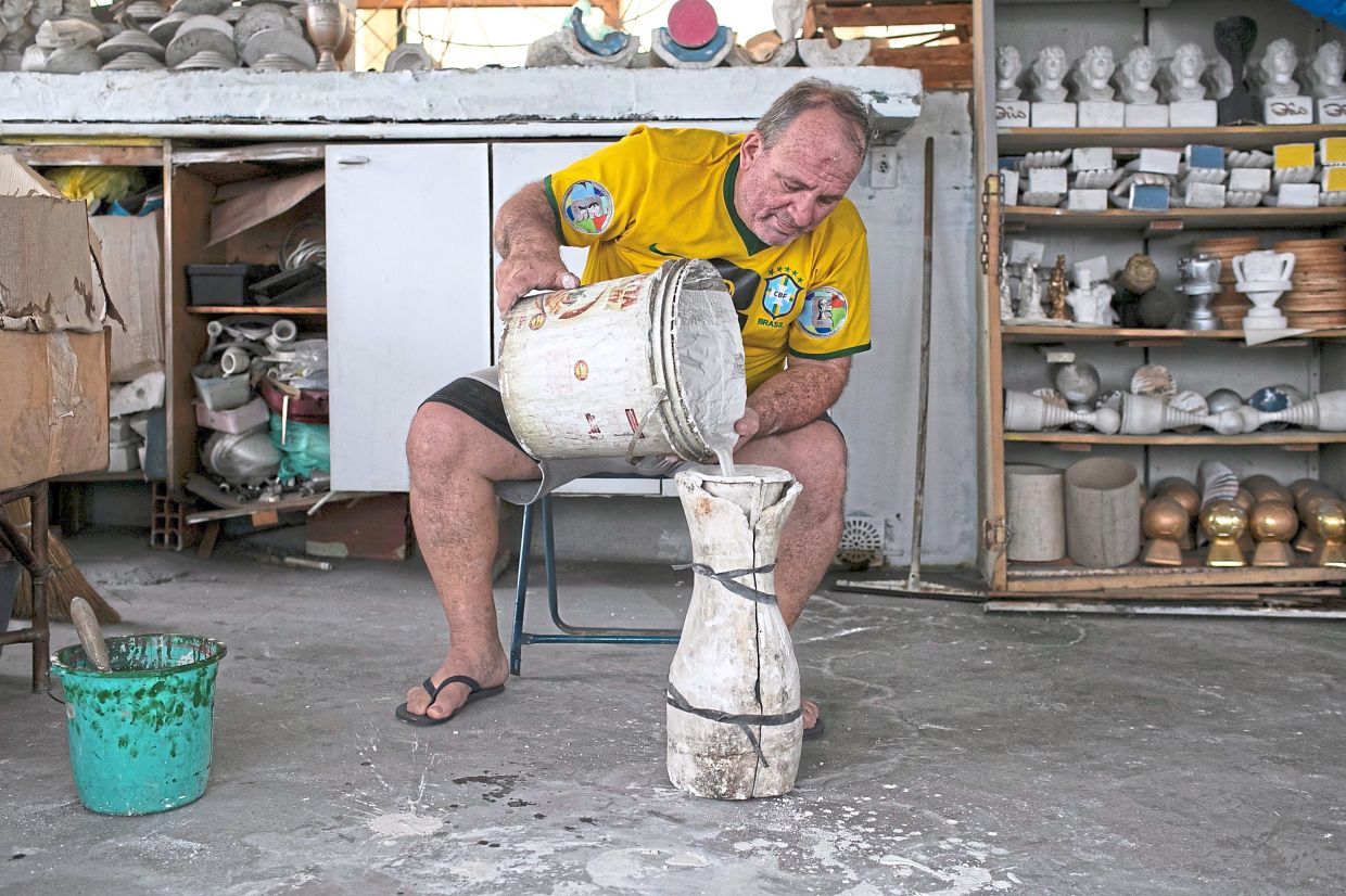 Carlini demonstrates how he makes FIFA World Cup trophy replicas at his home in Rio de Janeiro. Photo: AP 