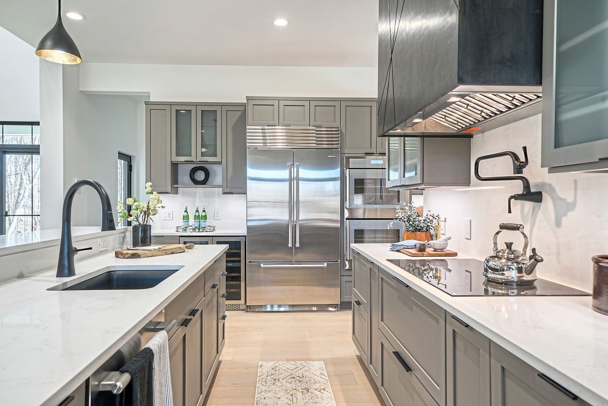 Gray cabinetry paired with black fixtures and a white countertop creates a modern, yet traditional vibe.