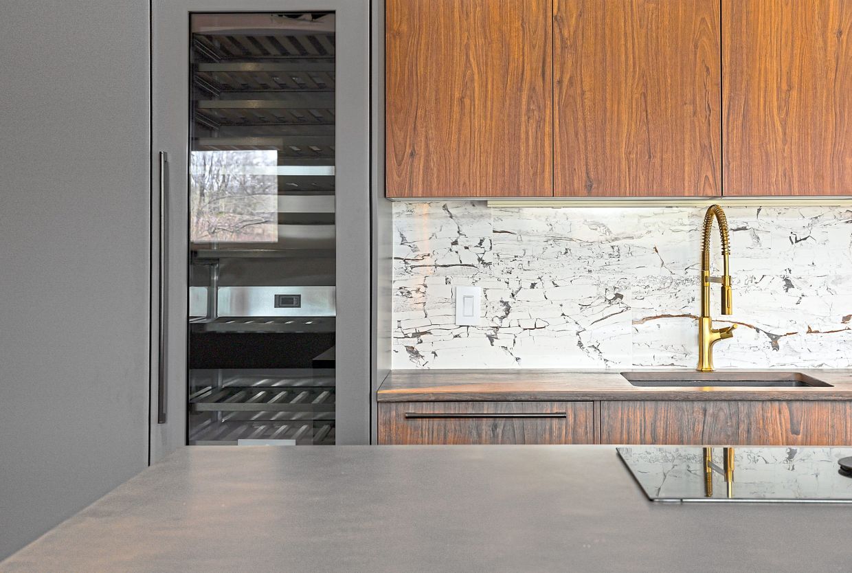 Elements such as a concrete countertops, including one manufactured to mimic wood is highlighted by a ceramic backsplash.