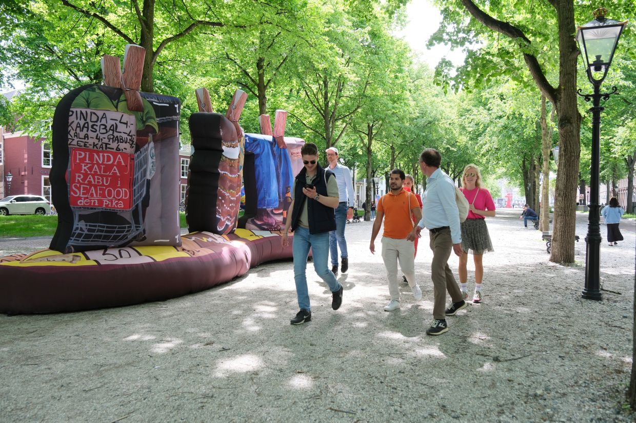 Peope walk by an art installation titled 'Koncha pa dilanti' by Eugenie Boon as part of the BlowUp Jubilee Art walk in the Hague, Netherlands. Photo: AP
