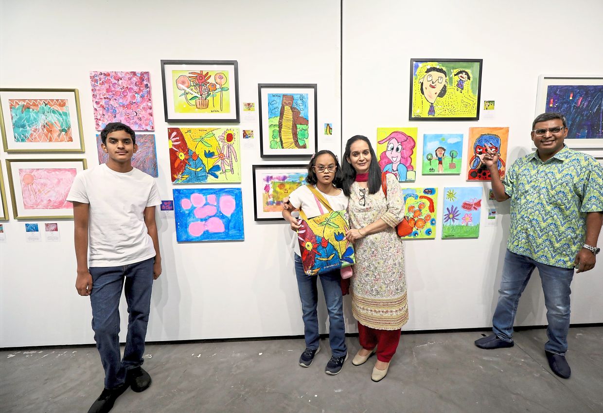 Madhuri (second from right) posing with Kritika and her artworks at the exhibition on special children’s paintings. With them are Madhuri’s husband Srimurugan Alagan (right) and son Aditya at FriendenArt’s Seni Mekar: Art In Bloom exhibition at Menara KEN in Taman Tun Dr Ismail.