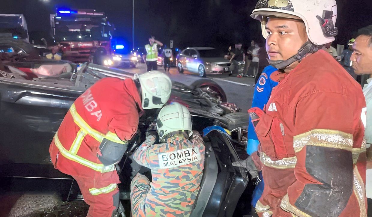 Tragic collision: Fire and Rescue Department personnel working at the scene of the accident along the Kuala Lumpur-bound Karak Expressway near Kampung Sungai Chinchin.