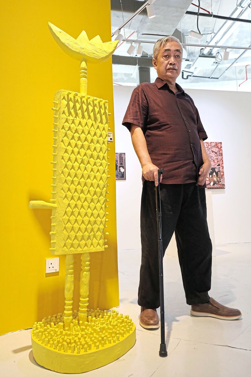 Tengku Sabri poses with his wooden sculpture ' Tengku Paduka Nakhoda Grogor Jiwo' (painted wooden structure, 2025). Photo: The Star/Azlina Abdullah 